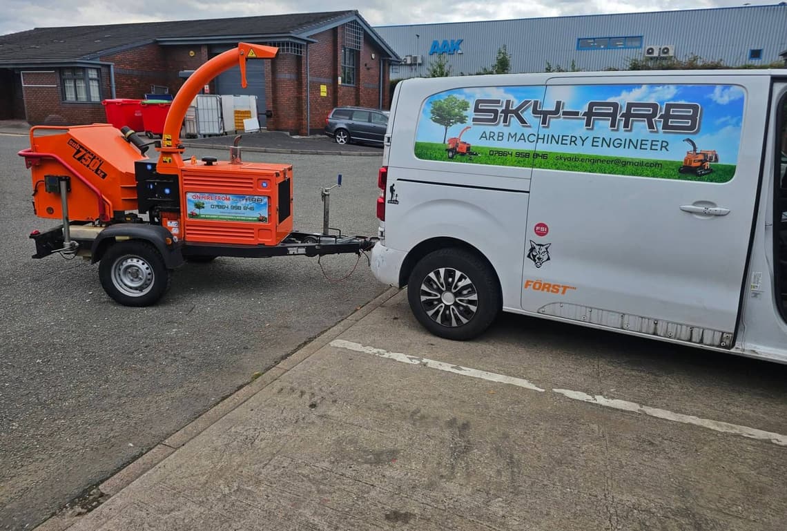 Sky-Arb's sign-written van towing an orange sub-750 kg wood chipper out on hire