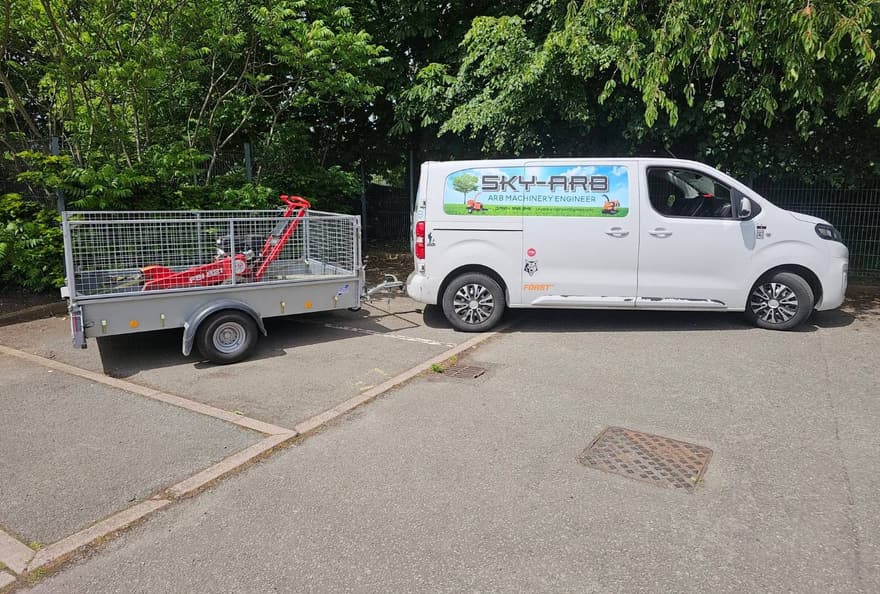 The Sky-Arb signwritten van and a caged trailer loaded with a stump grinder, ready to leave the unit